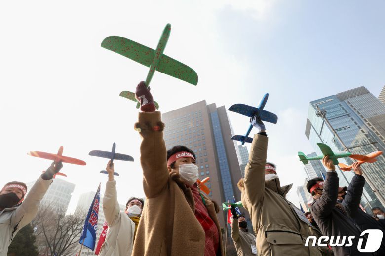 9일 서울 종로구 보신각 앞에서 열린 여행인 총궐기대회에서 한국여행업협회 등 참석자들이 비행기 모형을 날리는 퍼포먼스를 하고 있다. 2022.1.9/뉴스1 © News1 성동훈 기자