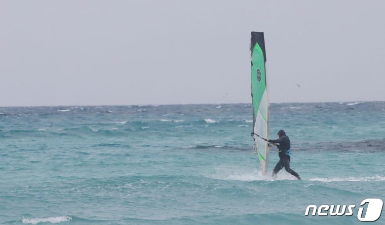 제주시 한림읍 협재해수욕장에서 한 레저객이 겨울 바다에서 윈드서핑을 즐기고 있다© News1