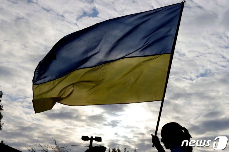 2022년 2월 26일(현지시간) 이스라엘 해안도시 텔아비브의 러시아 대사관 앞에서 한 시위대가 우크라이나 국기를 들고 있다. © AFP=뉴스1 © News1 김지현 기자