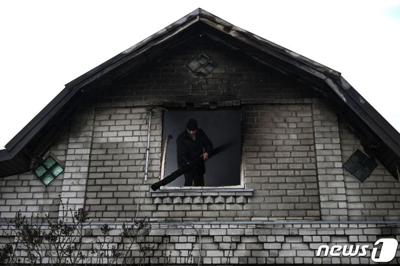 9일(현지시간) 우크라이나 수도 키이우 인근의 벨리카 디메르카에서 러시아 군의 포격을 받은 주택을 주민이 살펴 보고 있다. © AFP=뉴스1 © News1 우동명 기자