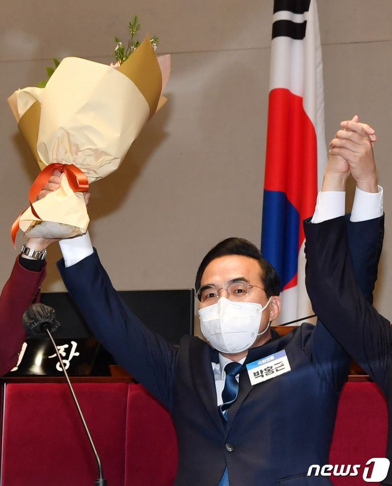 24일 더불어민주당 새 원내대표 선출 의원총회가 국회 예결위회의장에서 열렸다. 3차 결선 투표 결과 박홍근 의원이 선출됐다. 박 원내대표가 꽃다발을 들어올리고 있다. 2022.3.24/뉴스1 © News1 허경 기자