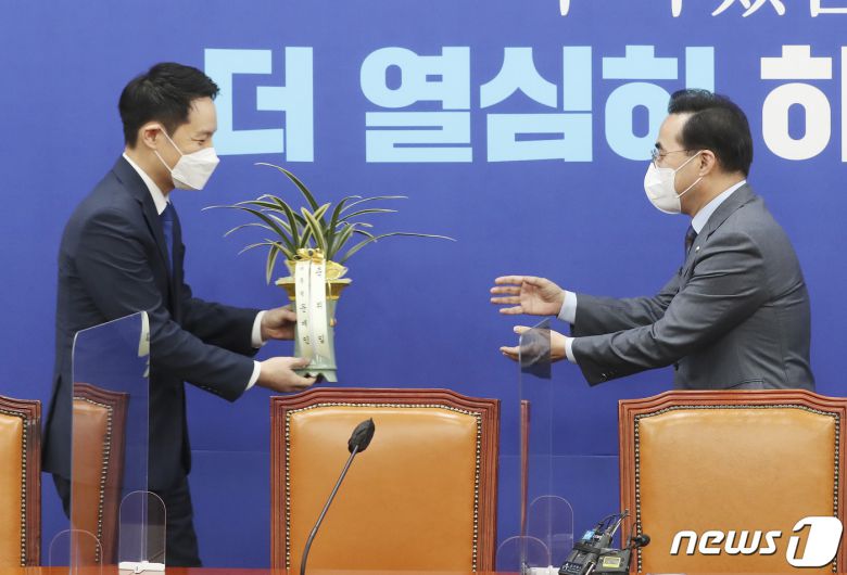 박홍근 더불어민주당 신임 원내대표가 25일 서울 여의도 국회 원내대표 회의실에서 김한규 대통령비서실 정무비서관에게 문재인 대통령의 축하난을 받고 있다. 2022.3.25/뉴스1 © News1 이동해 기자