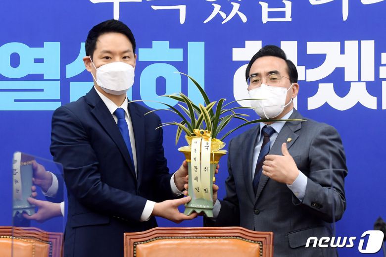 박홍근 더불어민주당 신임 원내대표(오른쪽)가 25일 오전 서울 여의도 국회에서 김한규 대통령비서실 정무비서관에게 문재인 대통령의 축하 난을 받고 감사 인사를 전하고 있다. 2022.3.25/뉴스1 © News1 이동해 기자