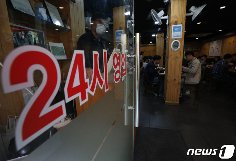 사회적 거리두기 개편 방안이 발표된 15일 서울 종로구 젊음의거리 식당가에 24시 영업을 알리는 안내문이 붙어 있다. 2022.4.15/뉴스1 © News1 신웅수 기자