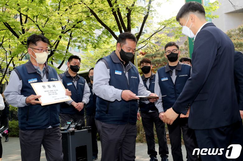 쌍용자동차노동조합 한상국 수석부위원장과 선목래 노조위원장이 21일 오전 서울 여의도 한국거래소 앞에서 상장폐지 개선기간 연장을 요청하며 관계자에게 청원서를 전달하고 있다. 2022.4.21/뉴스1 © News1 이동해 기자