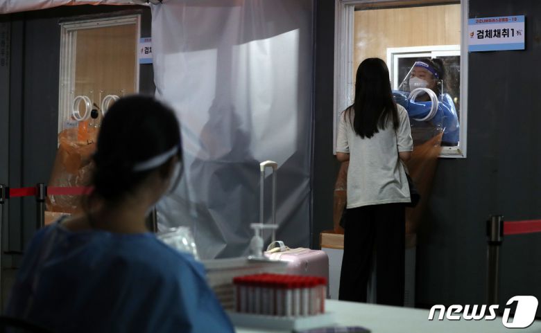 27일 저녁 서울 중구 서울역 신종 코로나바이러스(코로나19) 임시선별검사소에서 한 시민이 PCR검사를 받고 있다. 이날 코로나19 신규 확진자는 10만285명 발생해 3개월만에 10만명을 넘었다. 2022.7.27/뉴스1 © News1 박세연 기자