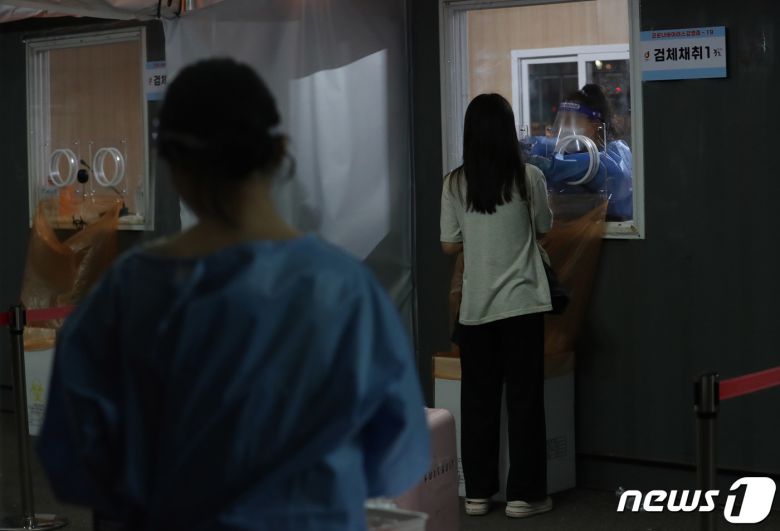 27일 저녁 서울 중구 서울역 신종 코로나바이러스(코로나19) 임시선별검사소에서 한 시민이 PCR검사를 받고 있다. 이날 코로나19 신규 확진자는 10만285명 발생해 3개월만에 10만명을 넘었다. 2022.7.27/뉴스1 © News1 박세연 기자