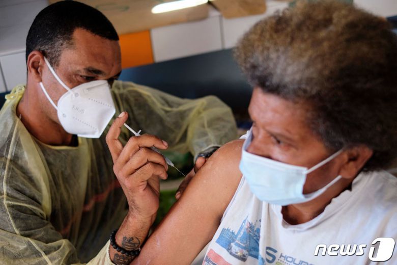 11일(현지시간) 남태평양의 프랑스령 뉴칼레도니아 라포아에 마련된 코로나19 백신 접종소에서 주민이 화이자 백신을 맞고 있다. ⓒ AFP=뉴스1 ⓒ News1 우동명 기자