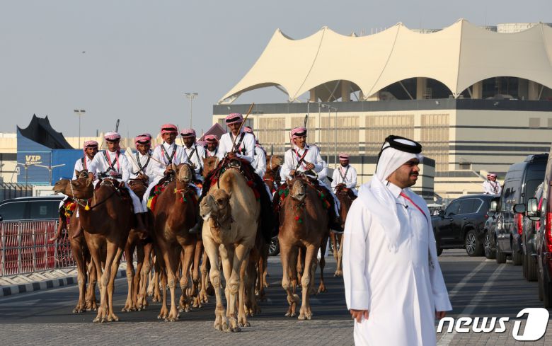 2022 카타르 월드컵 개막식을 앞둔 20일(현지시간) 카타르 알코르 알베이트 스타디움 입구에 낙타를 탄 남성들이 도열해 손님맞이를 하고 있다. 2022.11.20/뉴스1 ⓒ News1 이동해 기자