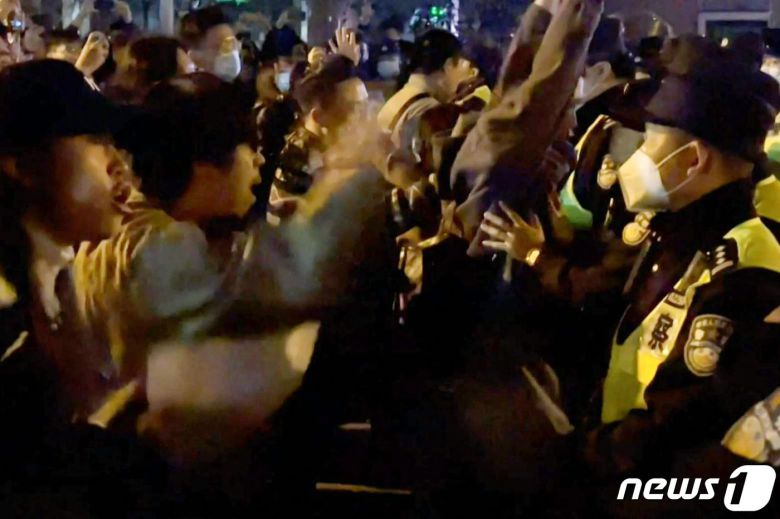 26일(현지시간) 중국 상하이에서 정부의 고강도 제로 코로나19 봉쇄 정책에 항의하는 주민들이 경찰에 항의하며 구호를 외치고 있다. ⓒ AFP=뉴스1 ⓒ News1 우동명 기자