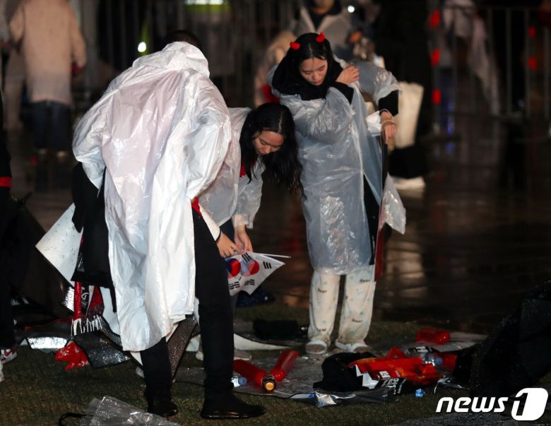 붉은악마와 시민들이 28일 밤 서울 광화문광장에서 2022 카타르 월드컵 H조 조별리그 2차전 대한민국과 가나의 경기응원을 마친 후 쓰레기를 치우고 있다. 2022.11.28/뉴스1 ⓒ News1 김진환 기자