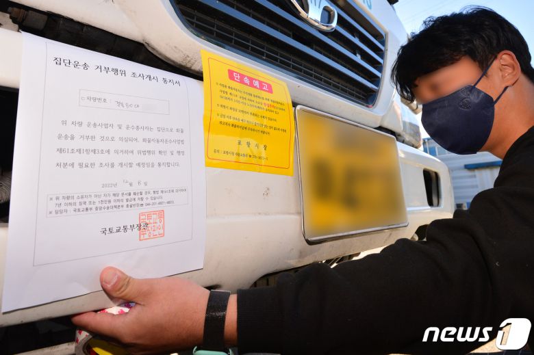 8일 오후 정부가 화물연대 파업과 관련 시멘트에 이어 철강과 정유부문에 업무개시명령을 발동했다. 국토부 관계자가 경북 포항시 남구 철강공단에 멈춰서 있는 화물연대 포항지부 소속 화물차량에 업무개시명령서(집단운송 거부행위 조사개시 통지서)를 부착하고 있다. 2022.12.8/뉴스1 ⓒ News1 최창호 기자