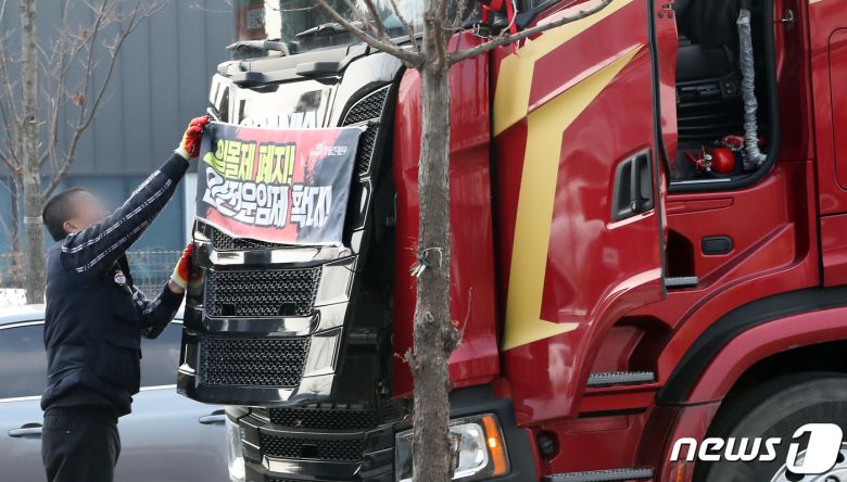 9일 민주노총 공공운수노조 화물연대의 파업철회 찬반투표 결과 파업종료로 가결 되면서 충남 당진시 현대글로비스 앞에서 파업 농성을 하던 화물연대 조합원이 화물차량에 부착한 '일몰제 폐지!, 안전운임제 확대' 플래카드를 철거하고 있다. 2022.12.9/뉴스1 ⓒ News1 김기남 기자