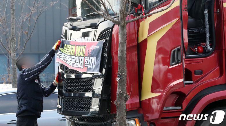 9일 민주노총 공공운수노조 화물연대의 파업철회 찬반투표 결과 파업종료로 가결 되면서 충남 당진시 현대글로비스 앞에서 파업 농성을 하던 화물연대 조합원이 화물차량에 부착한 '일몰제 폐지!, 안전운임제 확대' 플래카드를 철거하고 있다. 2022.12.9/뉴스1 ⓒ News1 김기남 기자