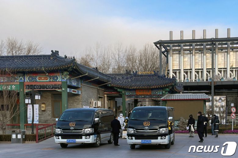 17일(현지시간) 중국 베이징 소재 한 장례식장 화장터 밖에서 코로나19 방호복을 착용한 근로자들이 관을 옮기고 있다. 2022.12.17 ⓒ 로이터=뉴스1 ⓒ News1 정윤미 기자