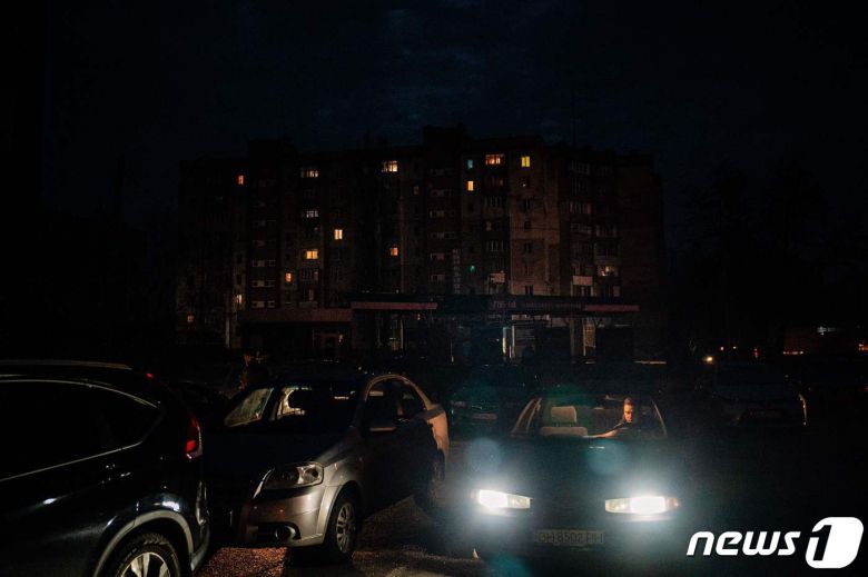 26일 (현지시간) 우크라이나 미콜라이우에서 정전의 어둠 속에 주민이 주차장서 차량을 타고 있다. ⓒ AFP=뉴스1 ⓒ News1 우동명기자