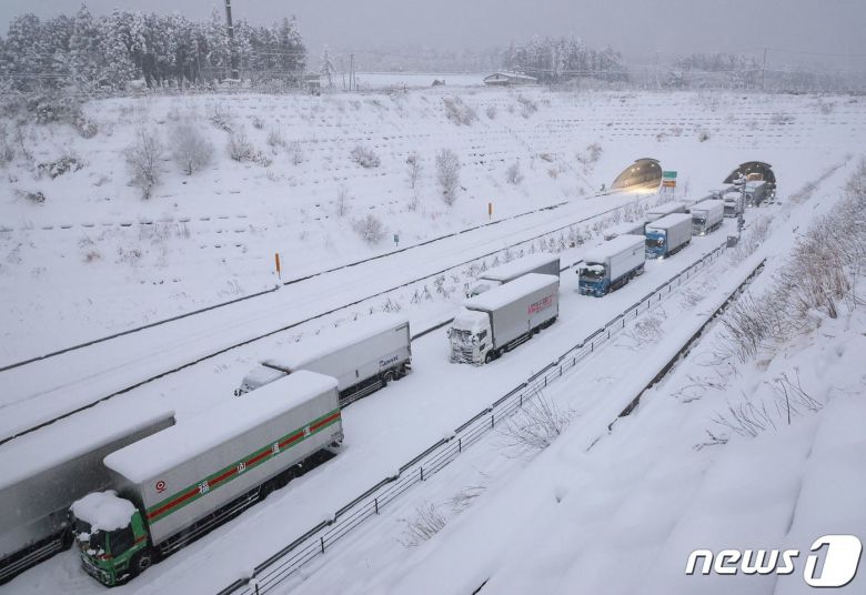 25일 (현지시간) 기록적인 한파에 폭설이 내린 일본의 욧카이치 신메이신고속도로에 트럭들이 멈춰 있다. ⓒ AFP=뉴스1 ⓒ News1 우동명 기자