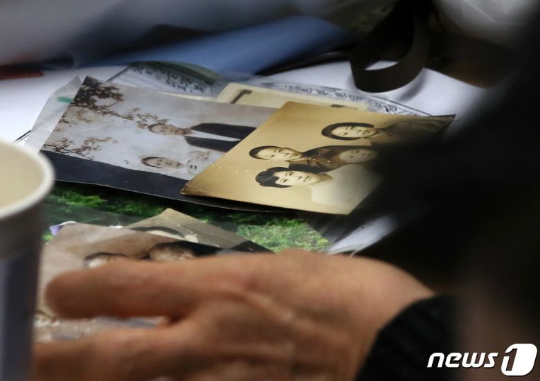 헤어진 뒤 서로 찾지 못하던 장기 실종 가족 장택훈, 장희재, 장경인, 장희란 남매가 31일 오후 서울 동작경찰서에서 58년 만에 다시 만나 가족사진을 보고 있다. 동작경찰서는 아동권리보장원과 함께 경찰 DNA 대조 등을 통해 지난 1965년 3월께 서울 노원구 태릉 부근에서 실종된 장 씨 가족 4남매 중 여동생 2명을 모두 찾아 이날 재회하는 자리를 마련했다. 2023.1.31/뉴스1 ⓒ News1 구윤성 기자