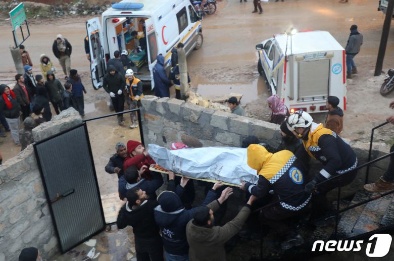 6일(혀지시간) 새벽 튀르키예 강진 여파로 진원지 인근 시리아 북서부 앗자즈의 한 건물이 붕괴된 가운데 구조 당국이 들것에 사망자를 실어 나르고 있다. 시리아 국영 사나통신에 따르면 국내 최소 111명이 숨지고 200명 이상이 부상을 입었다. 2023.2.6 ⓒ 로이터=뉴스1 ⓒ News1 정윤미 기자