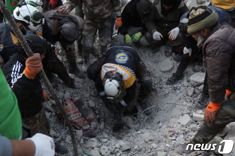 규모 7.8 강진 발생 사흘째인 8일(현지시간) 시리아 북서부 반군 점령지역 진디레스에서 한 구조대원이 무너진 건물 잔해에 깔린 어린아이들을 구조하기 위해 콘크리트 더미를 헤치고 있다. 2023.2.8. ⓒ AFP=뉴스1 ⓒ News1 김성식 기자