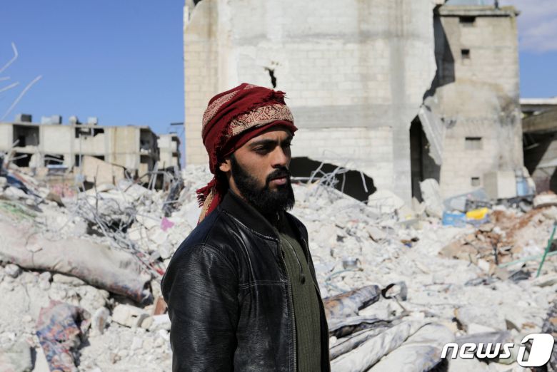 8일(현지시간) 시리아 잔다리스 마을에서 매형과 조카를 구한 살라 알하지 알 아캅이 잔해더미를 바라보고 있다. 그는 대지진으로 누나와 어린 조카를 잃었다. ⓒ 로이터=뉴스1 ⓒ News1 권진영 기자