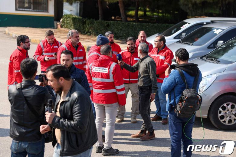12일(현지시간) 시리아 북서부 이들리브주에서 카타르 의료진이 대지진 피해를 입은 시리아 반군 점령지역으로 넘어가기 위해 국경 인근에 모였다. 빨간 점퍼를 입은 대원들이 인터뷰를 하고 있다. ⓒ AFP=뉴스1 ⓒ News1 권진영 기자