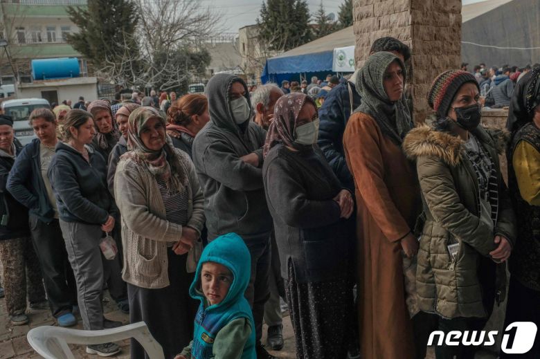 19일 (현지시간) 규모 7.8의 지진이 강타한 튀르키예 아디야만에서 주민들이 구호품을 받기 위해 줄을 서 있다. ⓒ AFP=뉴스1 ⓒ News1 우동명 기자