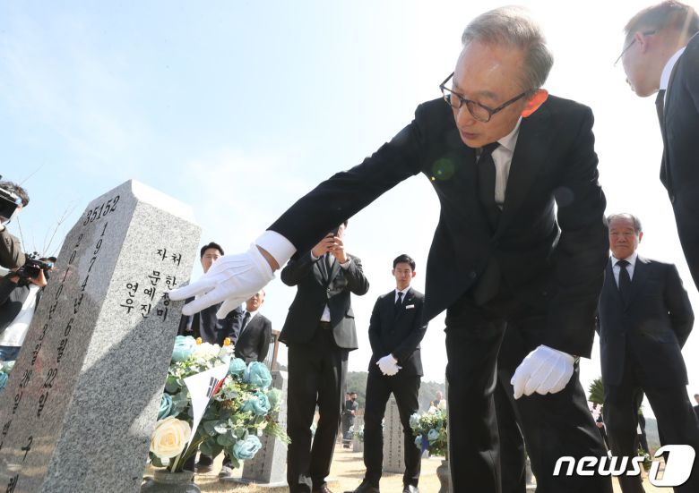 이명박 전 대통령이 서해수호의 날을 앞두고 22일 대전 유성구 국립대전현충원을 찾아 천안함 46용사 묘역에 참배한 뒤 묘비를 어루만지고 있다. 2023.3.22/뉴스1 ⓒ News1 김기태 기자