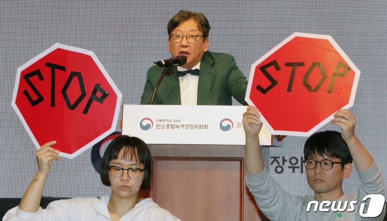 김상협 탄소중립녹색성장위원장이 22일 서울 강남구 한국과학기술회관에서 열린 국가탄소중립 녹색성장 기본계획 수립 등에 대한 공청회에서 발언하고 있는 가운데 환경단체 회원들이 기본계획 철회를 촉구하며 피켓 시위를 하고 있다. 2023.3.22/뉴스1 ⓒ News1 박세연 기자