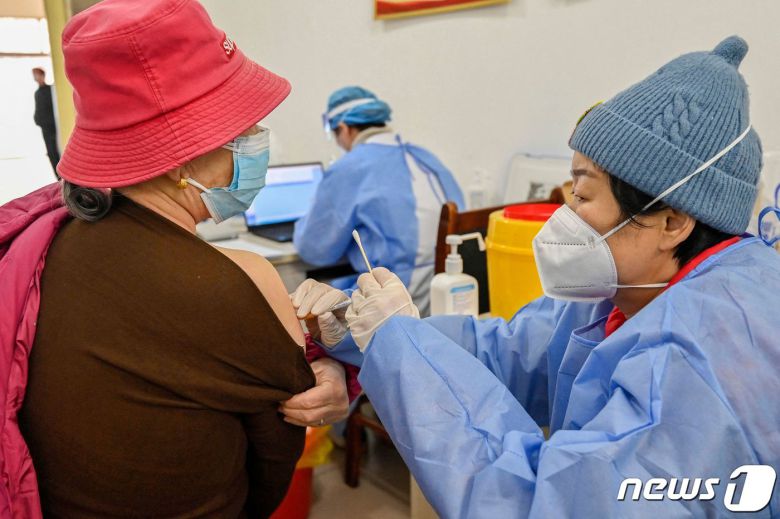 29일(현지시간) 코로나19 확산 속 중국 산둥성 칭저우의 백신 접종소에서 주민이 백신을 맞고 있다. ⓒ AFP=뉴스1 ⓒ News1 우동명 기자
