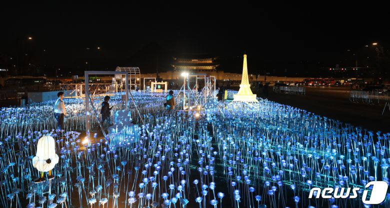 30일 오후 서울 종로구 광화문광장에서 열린 '광화에서 빛; 나이다'를 찾은 시민들이 불 밝힌 LED 장미를 살펴보고 있다. 2023.3.30/뉴스1 ⓒ News1 김진환 기자