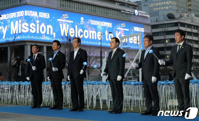한덕수 국무총리를 비롯한 참석자들이 30일 오후 서울 종로구 광화문광장에서 열린 2030 부산세계박람회(EXPO) 유치 기원 점등식에서 장미꽃을 들고 LED 장미꽃을 점등하는 퍼포먼스를 하고 있다. 사진 왼쪽 두 번째부터 두번째부터 장성민 대통령실 미래전략기획관, 한 총리, 이창양 산업통상자원부 장관, 윤상직 부산엑스포 유치위원회 사무총장, 안병윤 부산시 행정부시장. 2023.3.30/뉴스1 ⓒ News1 김진환 기자