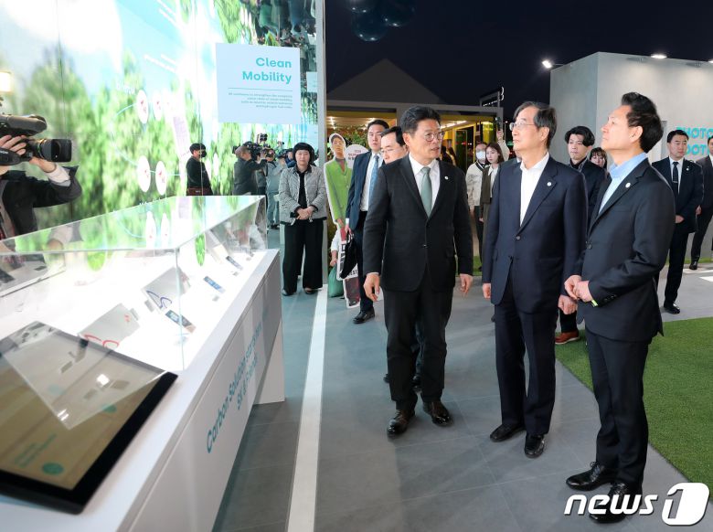 한덕수 국무총리를 비롯한 참석자들이 30일 오후 서울 종로구 광화문 광장에 마련된 2030 부산세계박람회(EXPO) 유치 기원 점등식을 마친 뒤 SK 부스를 방문, 저탄소 친환경 사업에 대한 설명을 듣고 있다. 2023.3.30/뉴스1 ⓒ News1 김진환 기자