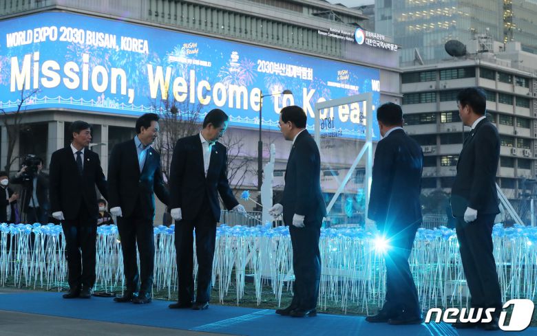 한덕수 국무총리를 비롯한 참석자들이 30일 오후 서울 종로구 광화문광장에서 열린 2030 부산세계박람회(EXPO) 유치 기원 점등식에서 장미꽃을 들고 LED 장미꽃을 점등하는 퍼포먼스를 하고 있다. 사진 왼쪽 두 번째부터 두번째부터 장성민 대통령실 미래전략기획관, 한 총리, 이창양 산업통상자원부 장관, 윤상직 부산엑스포 유치위원회 사무총장, 안병윤 부산시 행정부시장. 2023.3.30/뉴스1 ⓒ News1 김진환 기자