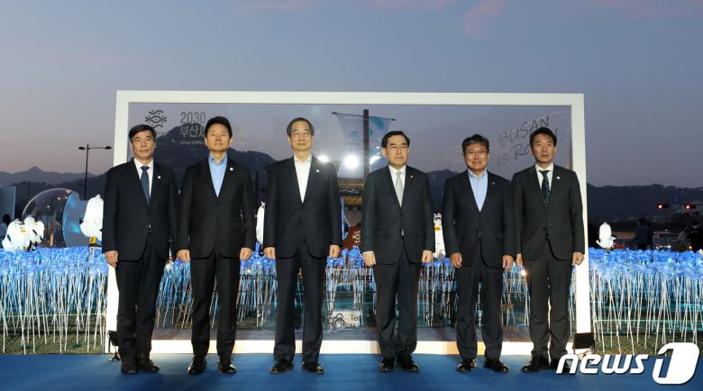 한덕수 국무총리를 비롯한 참석자들이 30일 오후 서울 종로구 광화문광장에서 열린 2030 부산세계박람회(EXPO) 유치 기원 점등식에서 퍼포먼스를 마친 후 기념 촬영을 하고 있다. 사진 왼쪽 두 번째부터 두번째부터 장성민 대통령실 미래전략기획관, 한 총리, 이창양 산업통상자원부 장관, 윤상직 부산엑스포 유치위원회 사무총장, 안병윤 부산시 행정부시장. 2023.3.30/뉴스1 ⓒ News1 김진환 기자