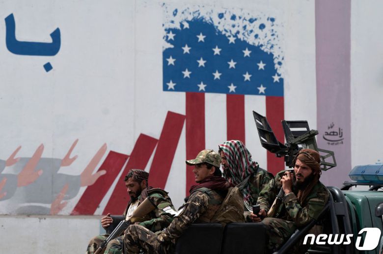 12일(현지시간) 아프가니스탄 수도 카불 소재 미국 대사관 벽 앞에 탈레반 정부군이 군용차량을 타고 지나가고 있다. 2022.04.12 ⓒ AFP=뉴스1 ⓒ News1 정윤미 기자