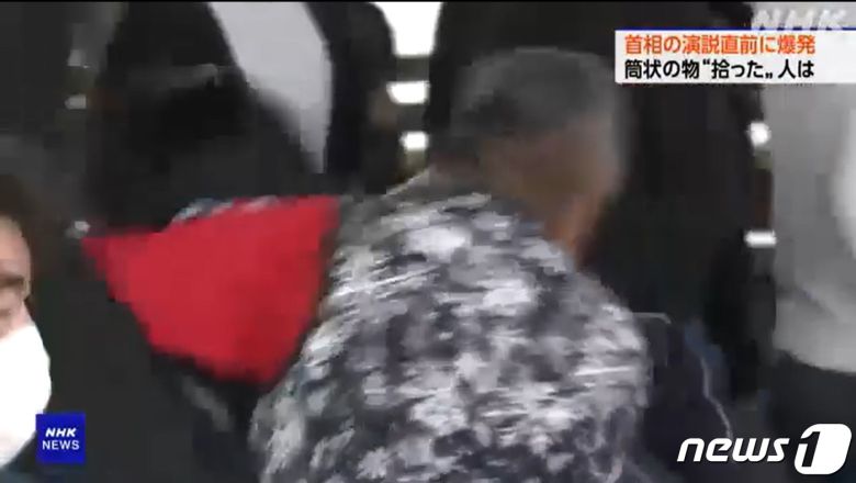 15일 일본 혼슈 남쪽 와카야마현 와카야마시 사이카자키 항구에서 중의원 와카야마 1구 보궐선거 지원에 나선 기시다 후미오 총리를 향해 폭탄 투척 사건이 발생한 가운데 한 남성이 용의자에게 헤드록을 걸고 있다. NHK 화면 캡처