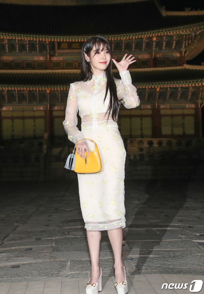 가수 겸 배우 아이유가 16일 서울 종로구 경복궁 근정전 입구에서 진행된 구찌(Gucci)의 2024 크루즈 쇼 포토콜 행사에서 손 인사를 하고 있다. ⓒ News1 권현진 기자