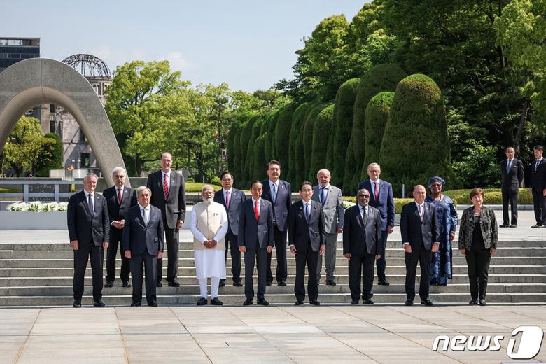 일본 히로시마 주요 7개국(G7) 정상회의에 참석한 정상들과 주요 기구 대표들이 21일 히로시마 평화기념공원 헌화에 앞서 사진 포즈를 취했다. 사진 앞쪽 왼쪽부터 마티아스 코먼 경제협력개발기구(OECD) 사무총장, 안토니우 구테흐스 유엔 사무총장, 나렌드라 모디 인도 총리, 조코 위도도 인도네시아 대통령, 기시다 후미오 일본 총리, 아잘리 아수마니 코모로 대통령, 마크 브라운 쿡제도 총리, 크리스탈리나 게오르기에바 국제통화기금(IMF) 사무총장, 뒷줄 왼쪽부터 파티 비롤 국제에너지기구(IEA) 사무총장, 데이비드 맬패스 세계은행(WB) 총재, 팜 민 찐 베트남 총리, 윤석열 대통령, 루이스 이나시우 룰라 다 시우바 브라질 대통령, 앤서니 앨버니지 호주 총리, 응고지 오콘조 이웨알라 세계무역기구(WTO) 사무총장 ⓒ 로이터=뉴스1 ⓒ News1 최종일 기자