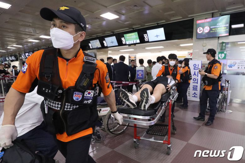 26일 오전 제주공항을 출발해 대구공항으로 향하던 아시아나 항공기에서 비행 중 문이 열리는 사고가 발생했다. 울산에서 열리는 제52회 전국소년체육대회에 참가하기 위해 비행기에 탑승했던 초·중학생 제주특별자치도 선수단 가운데 대구공항 도착 직후 고통을 호소하는 선수들을 119구조대가 들것을 이용해 구급차로 옮기고 있다. 2023.5.26/뉴스1 ⓒ News1 공정식 기자