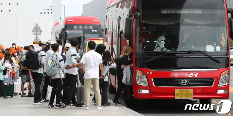26일 오전 제주에서 대구로 향하던 아시아나 항공기에서 30대 남성이 착륙 전 대구공항 상공에서 비상문을 강제개방하는 사고가 발생해 일부 승객이 병원으로 이송돼 치료를 받고 있다. 이날 울산에서 열리는 제52회 전국소년체육대회에 참가하기 위해 아시아나 항공기에 탑승했던 초·중학생 제주특별자치도 선수단이 대구공항 도착 후 인솔 교사의 안내를 받아 전세버스에 오르고 있다. 2023.5.26/뉴스1 ⓒ News1 공정식 기자