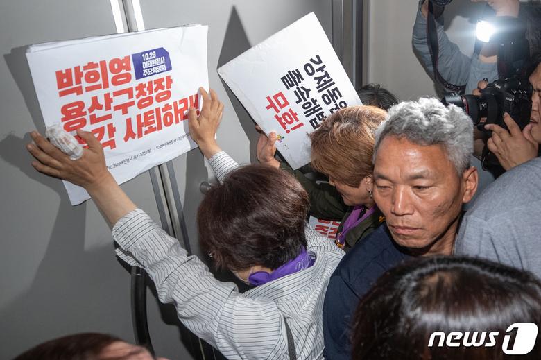 이태원 참사 유가족들이 8일 오전 서울 용산구청에서 이태원 참사에 부실하게 대응한 혐의로 기소된 박희영 용산구청장 출근을 저지하기 위해 손피켓을 들고 항의하고 있다. 2023.6.8/뉴스1 ⓒ News1 이재명 기자