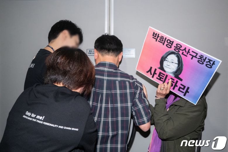 이태원 참사 유가족들이 8일 오전 서울 용산구청에서 이태원 참사에 부실하게 대응한 혐의로 기소된 박희영 용산구청장 출근을 저지하기 위해 손 피켓을 들고 항의하고 있다. 2023.6.8/뉴스1 ⓒ News1 이재명 기자