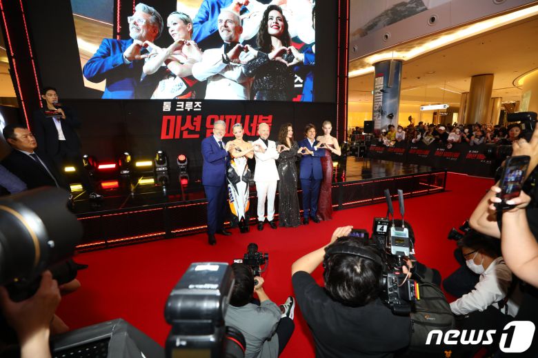 크리스토퍼 맥쿼리 감독(왼쪽부터)과 할리우드 배우 폼 클리멘티에프, 사이먼 페그, 헤일리 앳웰, 톰 크루즈, 바네사 커비가 29일 서울 송파구 롯데시네마 월드타워점에서 열린 영화 '미션 임파서블: 데드 레코닝 파트 원' 레드카펫 행사에서 체인 하트를 그리고 있다. ⓒ News1 권현진 기자