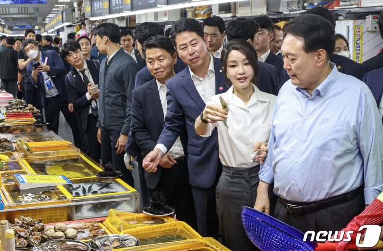 윤석열 대통령 부인 김건희 여사가 27일 부산 중구 자갈치시장을 찾아 수산물을 살펴본 뒤 새우를 들어보이고 있다. 2023.7.27/뉴스1 ⓒ News1 부산사진공동취재단