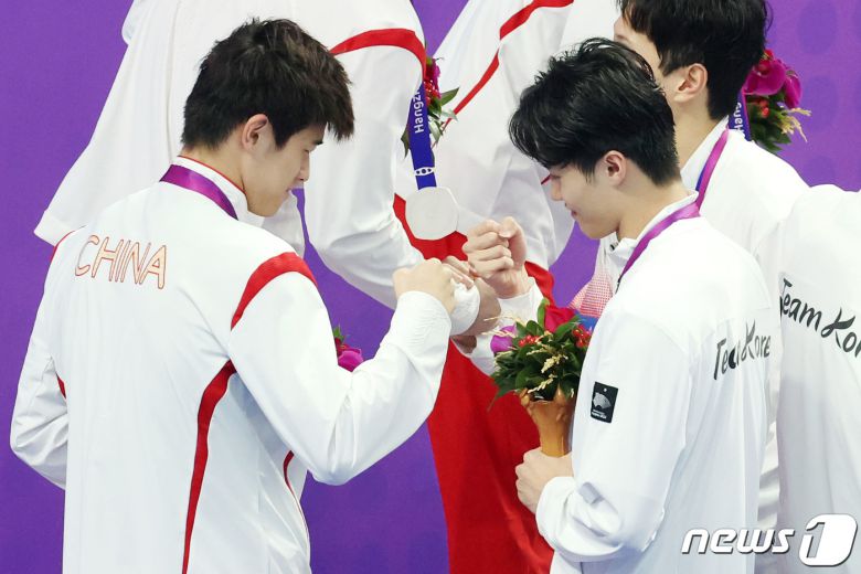 25일 오후 중국 항저우 올림픽 스포츠센터 수영장에서 열린 남자 계영 800ｍ 결승전이 끝난 뒤 대한민국 황선우가 중국의 판잔와 주먹 인사를 나누고 있다. 2023.9.25/뉴스1 ⓒ News1 민경석 기자