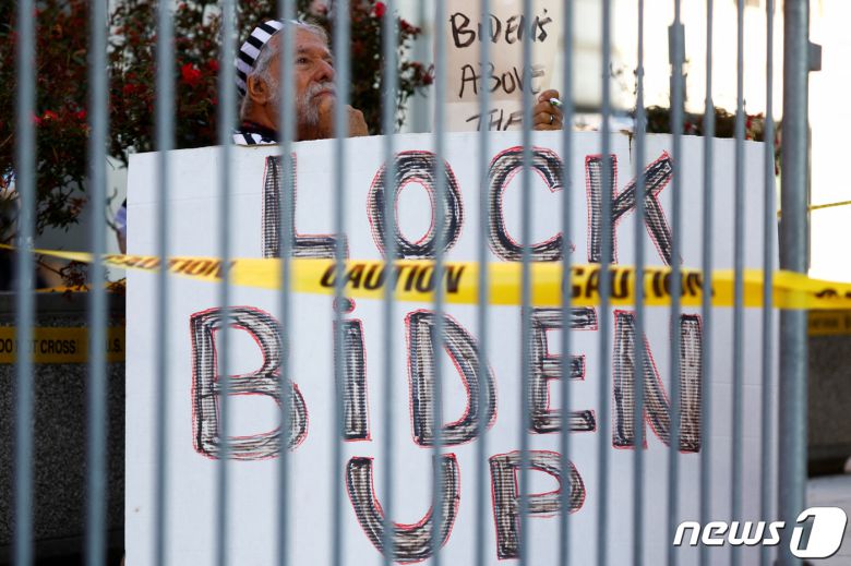 조 바이든 미국 대통령의 차남 헌터 바이든이 3일(현지시간) 미국 델라웨어주 윌밍턴 연방법원에서 열린 총기 불법 소지 혐의와 관련한 기소인부 절차에 출석을 앞두고 있는 상황에서 마이애미 출신의 밥 쿤츠가 법원 밖 차단 구역에서 현수막을 들고 있다. ⓒ 로이터=뉴스1 ⓒ News1 김현 특파원