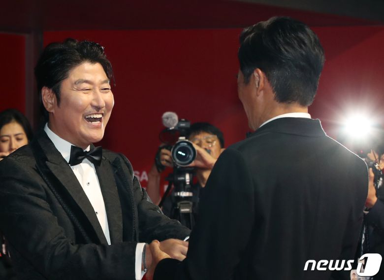 배우 송강호(왼쪽)가 4일 오후 부산 해운대구 영화의전당에서 열린 ‘제28회 부산국제영화제’(BIFF) 개막식에서 홍콩 영화계의 대부 주윤발을 맞이하고 있다. ⓒ News1 권현진 기자