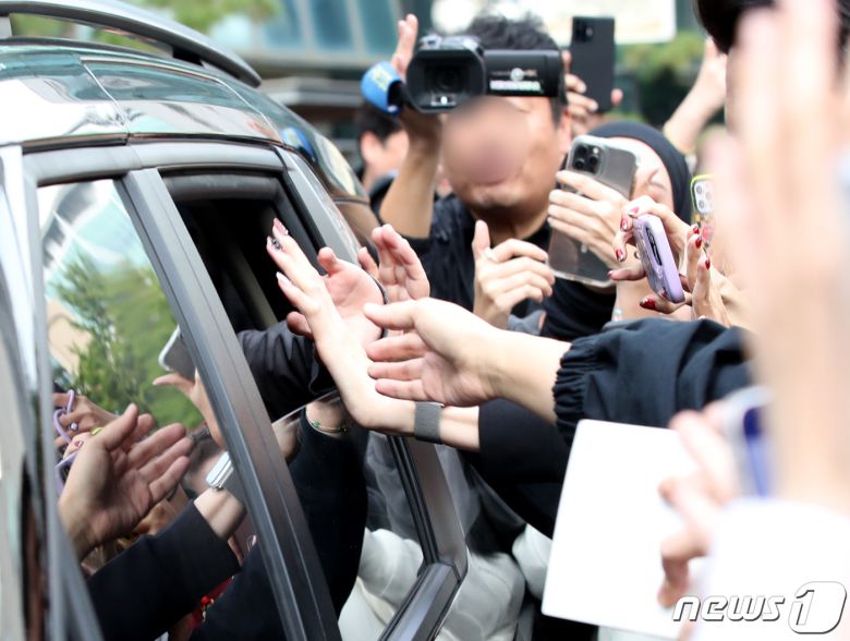 방탄소년단 정국이 13일 오전 서울 여의도 KBS 신관에서 진행된 '뮤직뱅크' 녹화를 마친 뒤  팬과 손터치로 인사를 전하며 이동하고 있다. ⓒ News1 권현진 기자