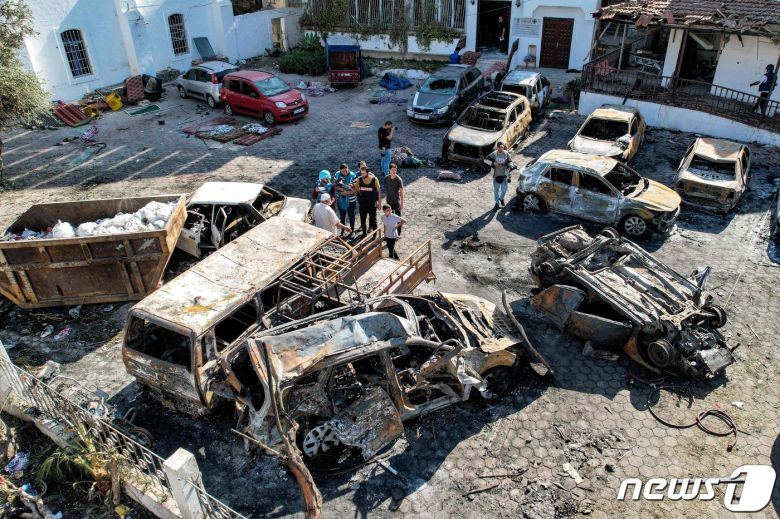 18일(현지시간) 팔레스타인 무장정파 하마스가 통치하고 있는 가자 지구의 병원 폭발 참사 현장의 파괴된 건물 앞에 불에 탄 차량들이 보인다. 2023.10.18 ⓒ AFP=뉴스1 ⓒ News1 우동명 기자